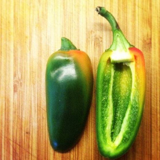 Pepper Jalapeno on cutting board, whole and sliced open.