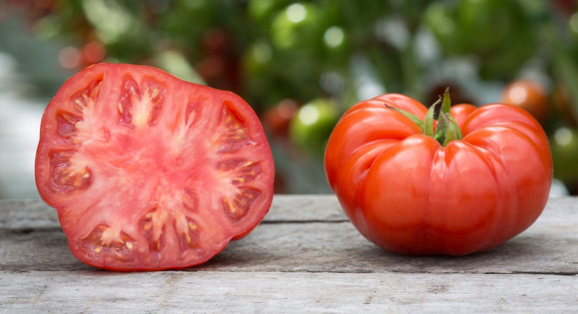 Beefsteak heirloom tomato whole and sliced, showcasing rich color and texture.
