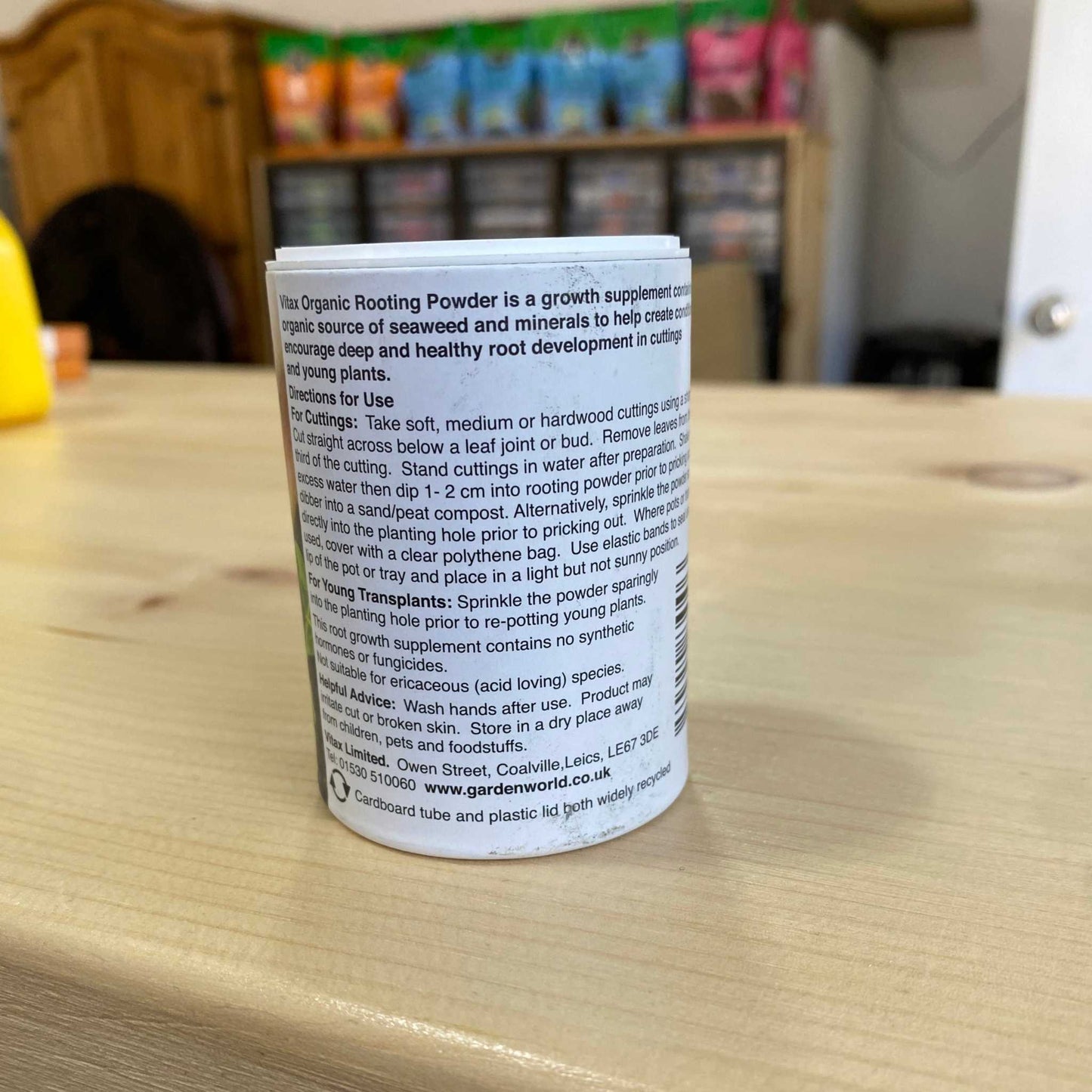 Organic Rooting Powder container for plant growth enhancement on a wooden surface.