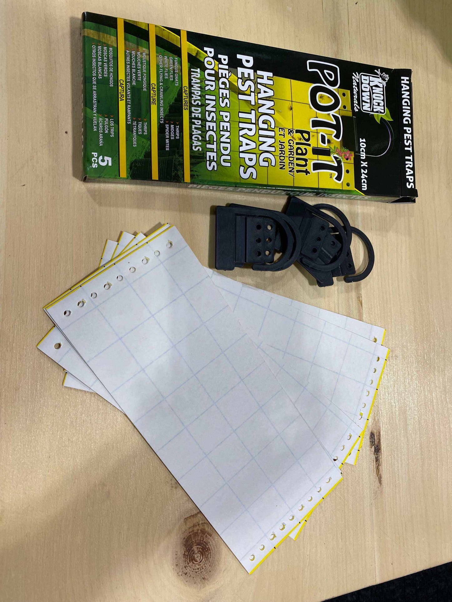 Yellow Insect Strip Traps with packaging and adjustable components on a wooden surface.