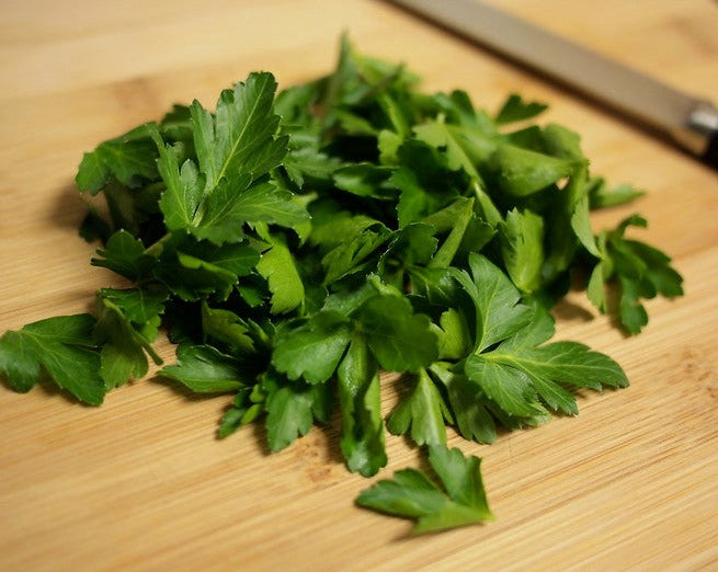 Dark Green Italian Parsley leaves on cutting board.