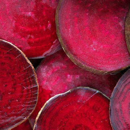 Red Ace beets sliced, showcasing their vivid red color and smooth texture.
