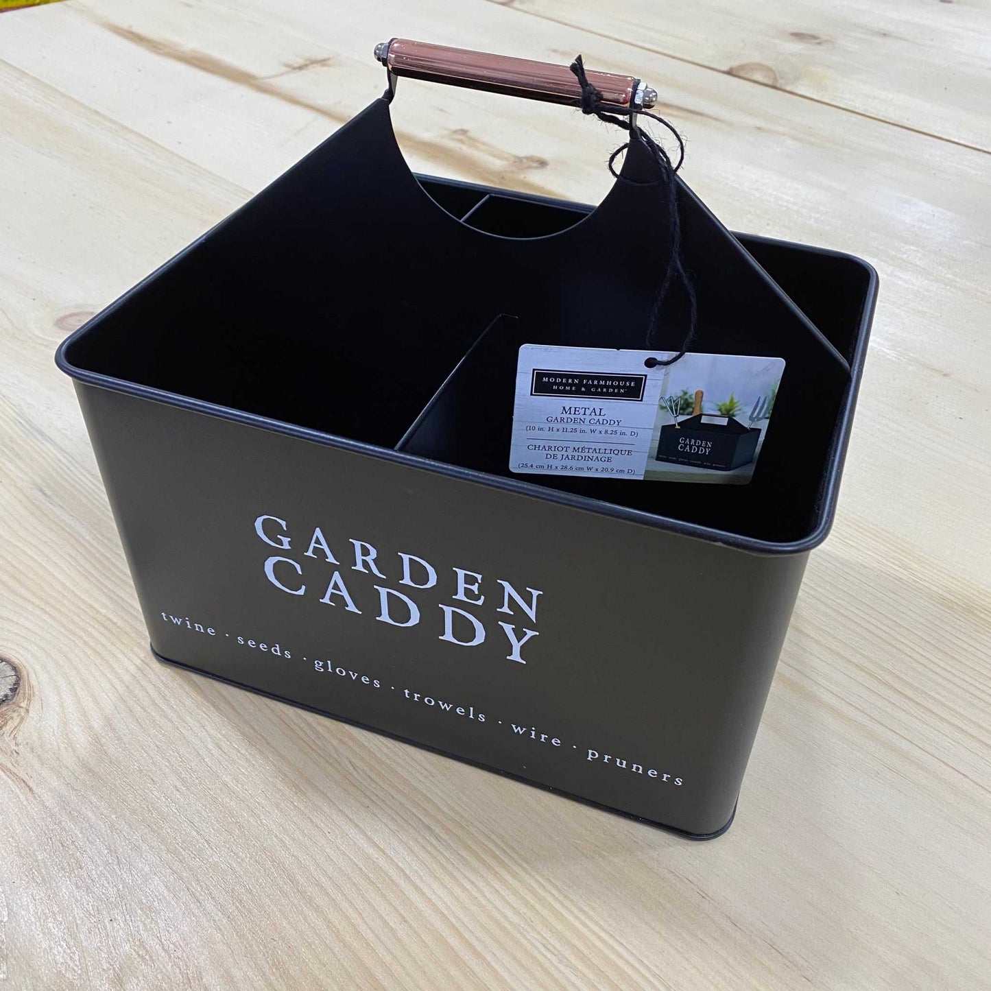 Decorative black metal garden caddy with handle, ideal for organizing tools and gardening supplies.