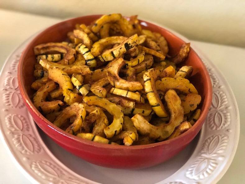 Dellacotta Squash slices in red bowl, showcasing rich flavors.